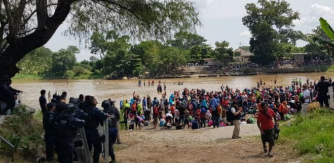 Migrantes forman cadena humana para cruzar el Río Suchiate